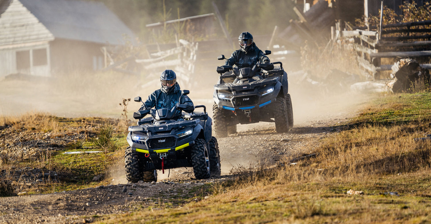 two people riding atvs on a dirt road